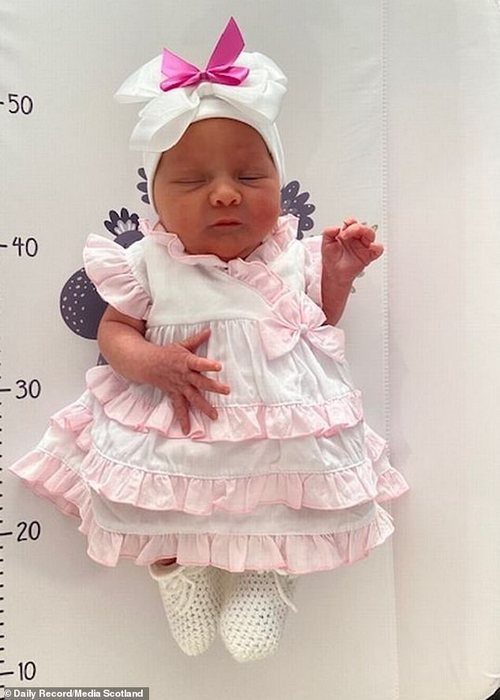 Tiny Daisy Grace looking relaxed in a ruffled skirt after her birth. Her mother spent 25 years wishing for a baby